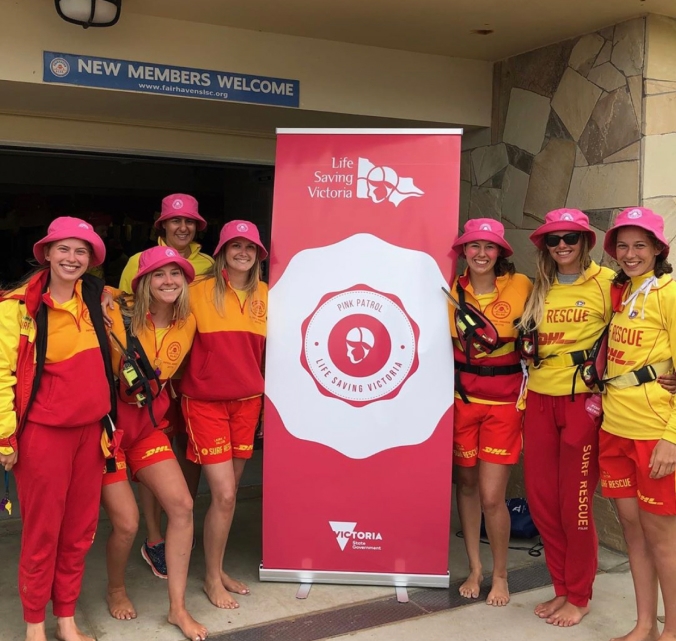 Life Saving Victoria volunteers standing next to banner